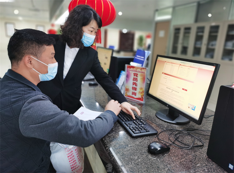 工作人員細(xì)心指導(dǎo)競(jìng)價(jià)人完善競(jìng)價(jià)資料（麥玉寧 攝）.jpg